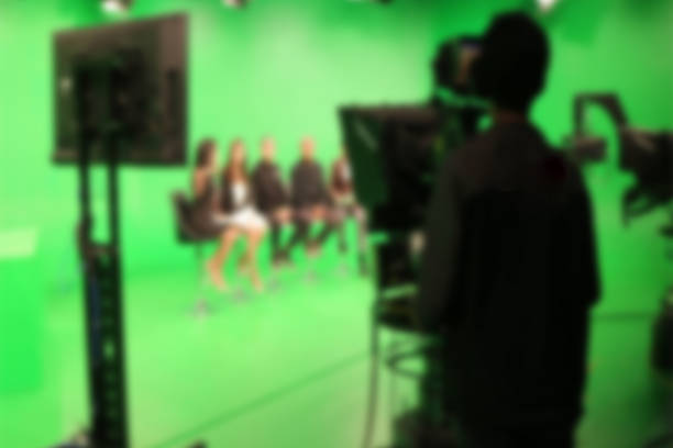 istock blur image A television presenter in a TV camera in studio a green screen. 931817358