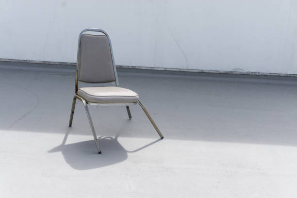 broken dead leather white chair on an outdoor concrete floor., with copy space for text.