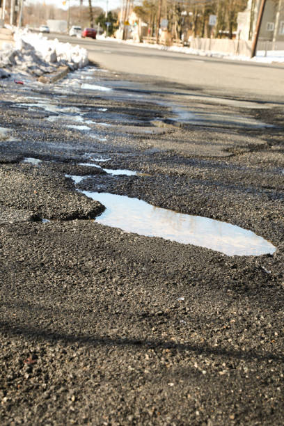 istock Large water filled pothole in the road 931831494