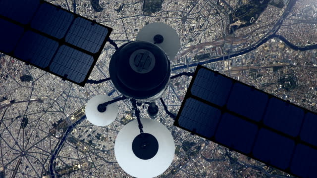 Telecomunication satellite sending signal to Earth. Flying over large city