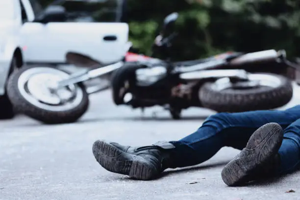 Victim of a motorbike accident lying on the street unconscious
