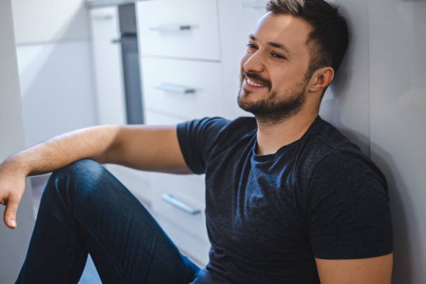 istock Handsome man sitting on the kitchen floor and smiling 931841010
