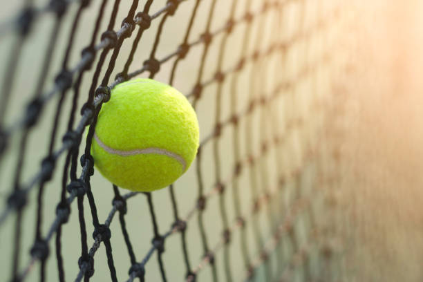 istock Close up tennis ball hitting to net on blur background 931843652