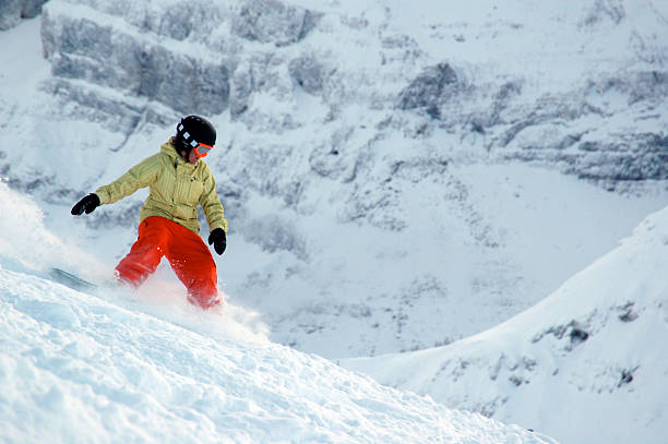 istock Snowboarder in orange and yellow rides through powder 93184477