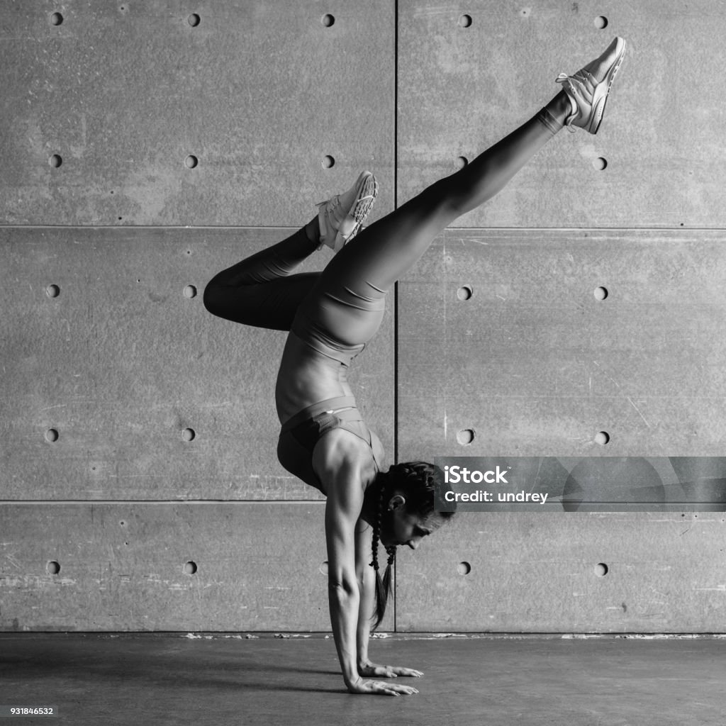 Young fit woman doing handstand exercise in studio. Young fit woman doing handstand exercise in studio Active Lifestyle Stock Photo