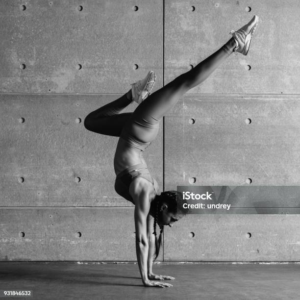 Young Fit Woman Doing Handstand Exercise In Studio Stock Photo - Download Image Now