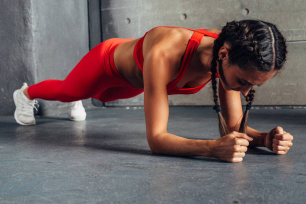 Side view of fit woman doing plank core exercise. Side view of fit woman doing plank core exercise forearm stock pictures, royalty-free photos & images