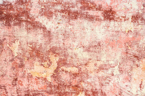 istock Pink-red Textured background of multi-layer flaking paint on the wall. Mixing different colors of paints in the cleaved layers on the surface. Grunge texture with a deep pattern 931854264