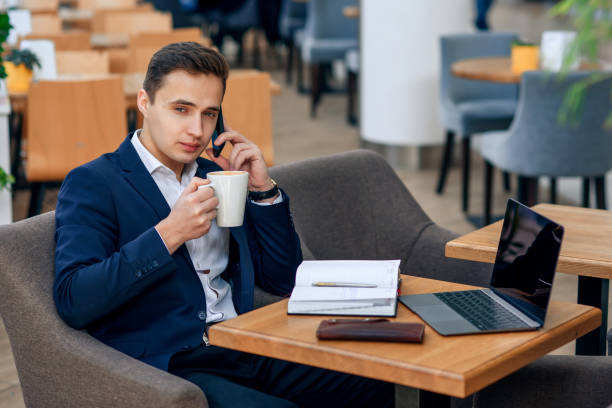 istock Overworked businessman have coffee break and speaking on smartphone. 931854326