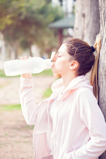 istock Young sportive woman drinking water at sunset 931857312