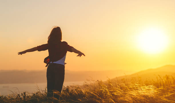 istock Happy woman   on sunset in nature iwith open hands 931869408