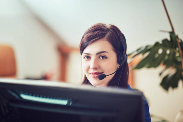 Face of young charming confident woman with headset stock photo