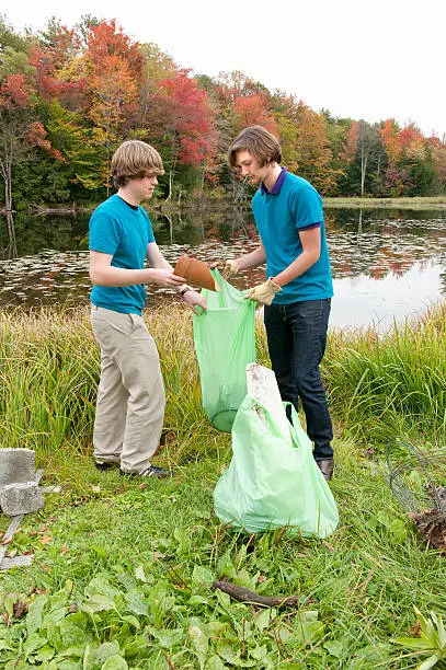 high school volunteers, green up day, located at local nature preserve by pond, autumn day