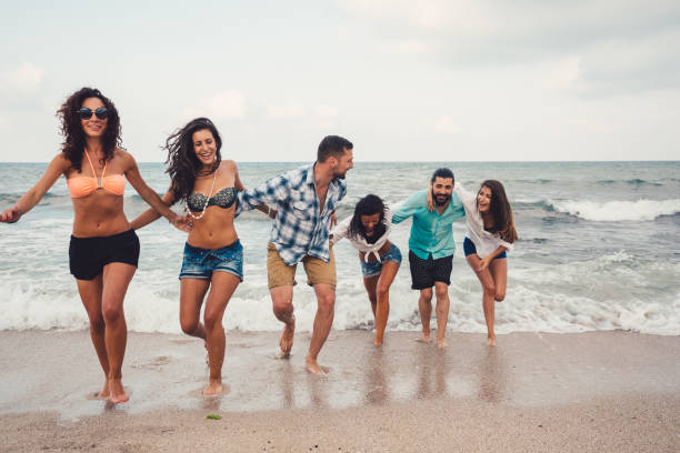 istock Group of friends running on beach 931879412