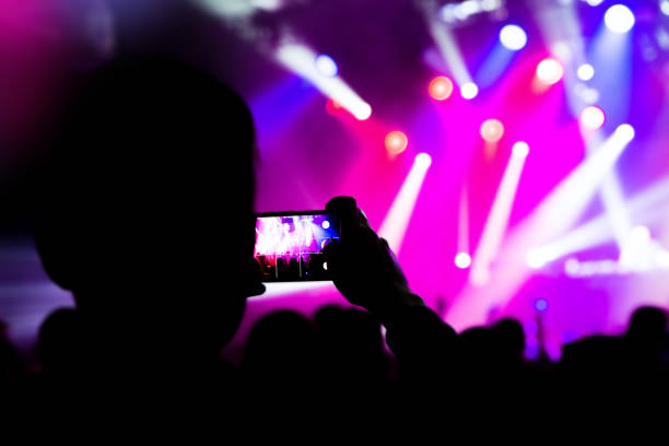 istock taking photo video mobile phone silhouettes crowd 931896480