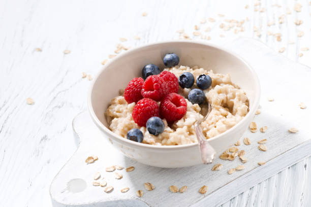 istock homemade oatmeal with berries on white wooden table 931896758