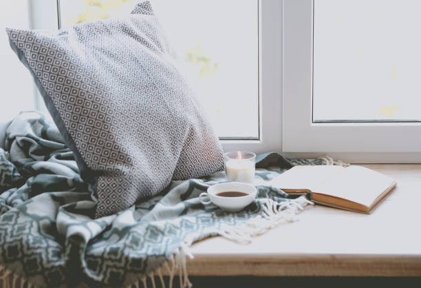 istock Cup of coffee, candle and book near window 931901094