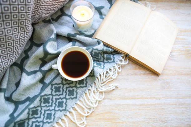 istock Cup of coffee, candle and book on the floor 931902320