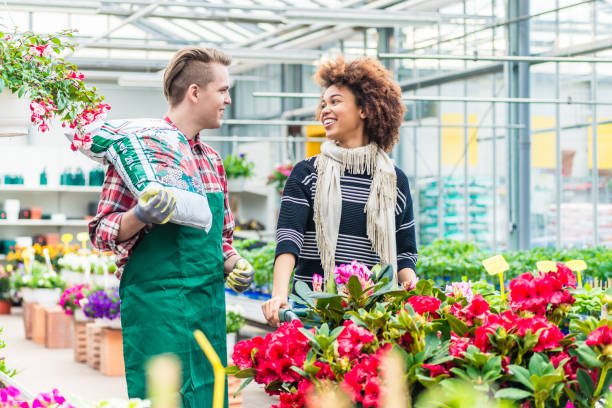 istock Cheerful handsome worker talking with a beautiful customer in a modern flower shop 931902848