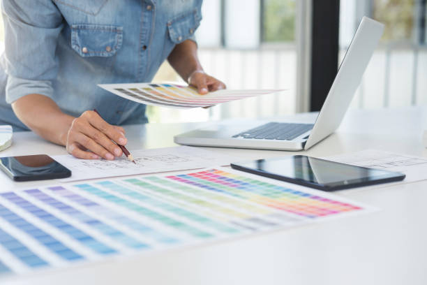 istock Color samples, colour chart, swatch sample, Graphic designer being selecting Color table and graphics tablet, pen at workplace with work example on wooden desk 931906936