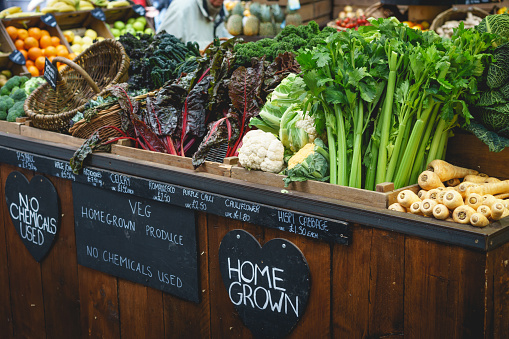 Vegetable stall in farmer market, including celery, parsnips and broccoli.