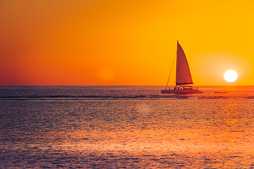 sunset ride with the sailboat near the reef of mauritius island in the indian ocean, africa.