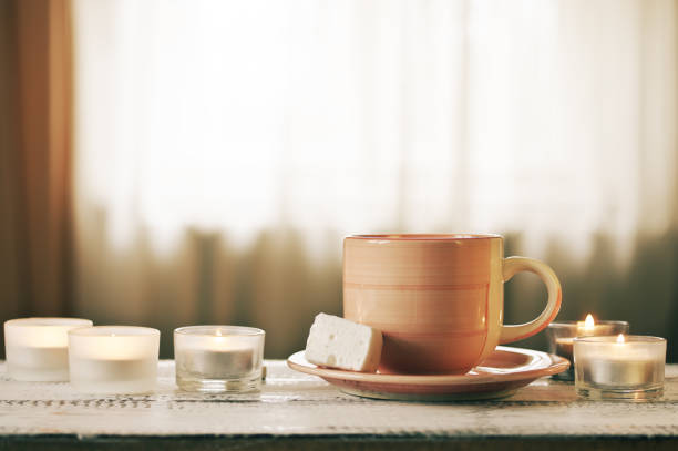 istock Cup of coffee and burning candles 931913830