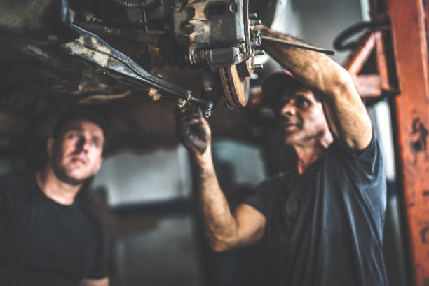 professionellen mechaniker reparieren einen mietwagen in autowerkstatt - dirty job stock-fotos und bilder