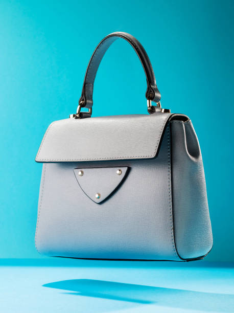 istock Stylish light gray leather women's handbag on blue background 931918050
