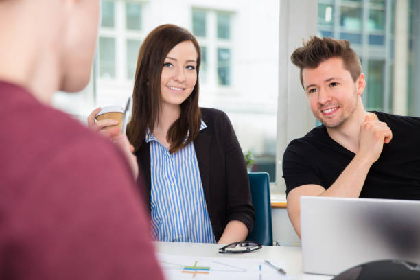 istock Business People Smiling While Looking At Colleague At Desk 931930026