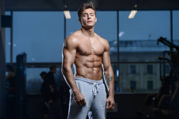 Handsome model young man workout in gym Handsome young fit muscular caucasian man of model appearance workout training in the gym gaining weight pumping up muscles and poses fitness and bodybuilding sport concept man muscular chest stock pictures, royalty-free photos & images