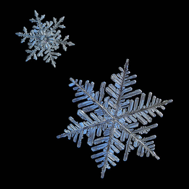 istock Two snowflakes isolated on black background 931934312