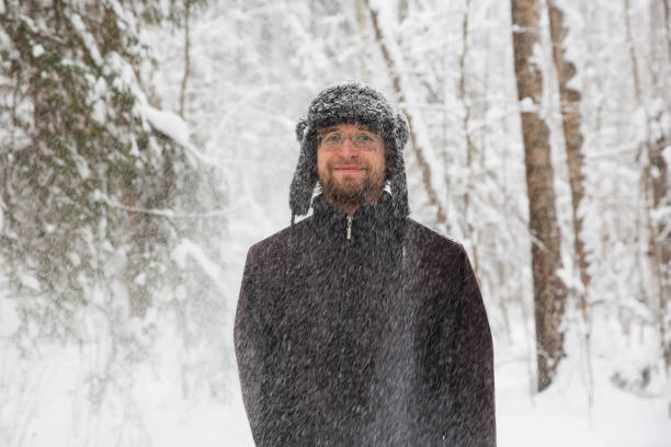 istock Man in fur winter hat with ear flaps smiling portrait 931934444