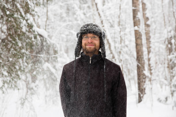 istock Man in fur winter hat with ear flaps smiling portrait 931937178