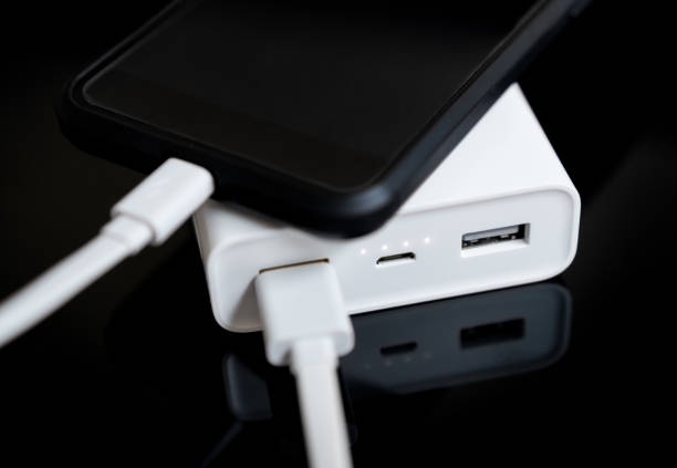 istock White power bank with smartphone on mirrored surface. 931938400