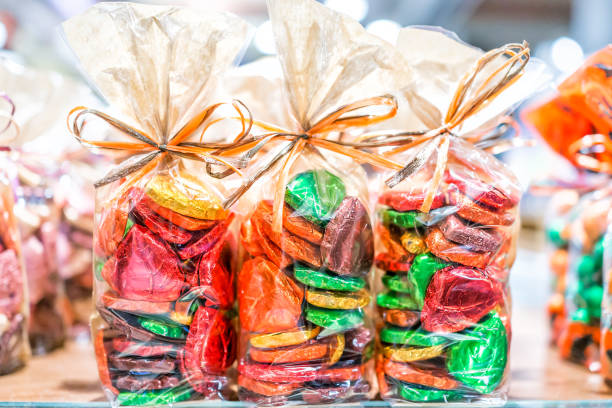 バッグ リボン赤箔休日で結ばれるカラフルなパッケージ包まれたチョコレートの心のお菓子店、緑、黄金、金、黄色の贈り物として - heart shape snack dessert symbol ストックフォトと画像