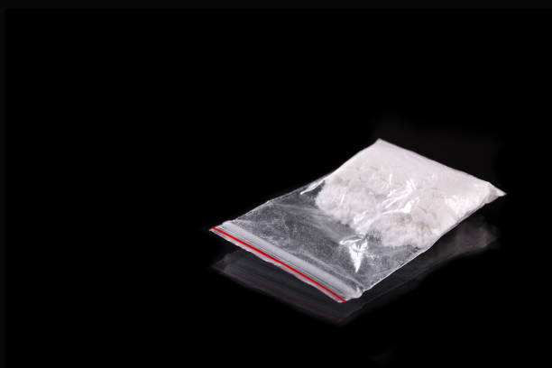 istock Cocaine in plastic packet on black background 931938782
