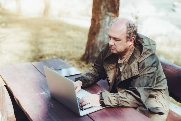 istock An aged man with the netbook is sitting outdoor 931941292