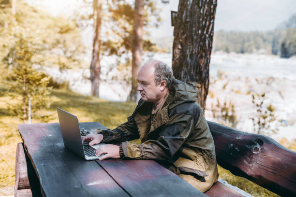 istock Businessman with laptop during his vacations in forest 931941568