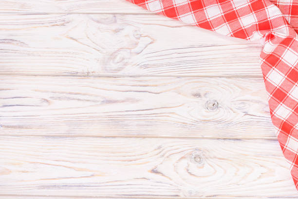 istock Red towel over wooden kitchen table. View from above with copy space 931944890