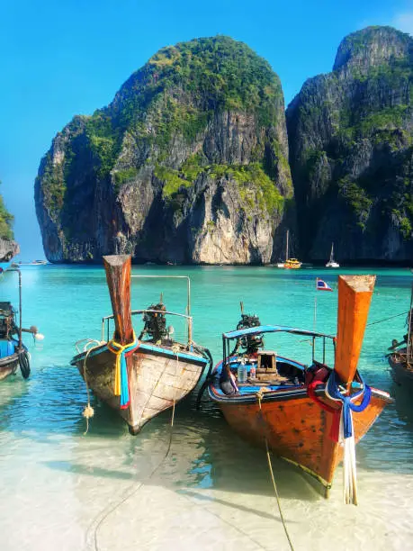 Longtail boats anchored at Maya Bay on Phi Phi Leh Island, Krabi Province, Thailand. It is part of Mu Ko Phi Phi National Park.