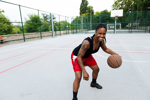 Happy young woman on a basketball training