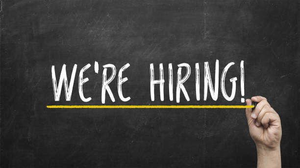 istock Hand with chalk writing We're hiring on black chalkboard 931993092