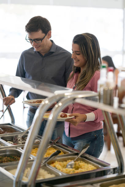 istock Group of people serving food at a self-service restaurant 931994168
