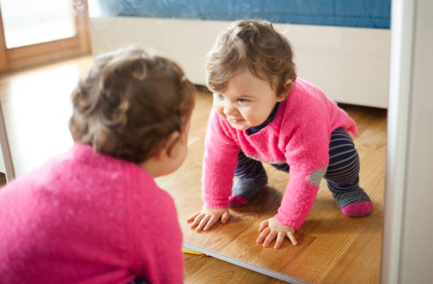 istock Cute Smiling Girl With Reflection On Mirror At Home 932007350