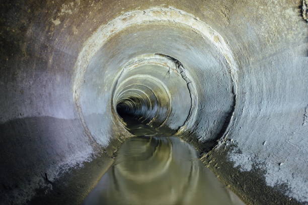 istock Dirty urban sewage flowing throw round sewer tunnel pipe 932008024