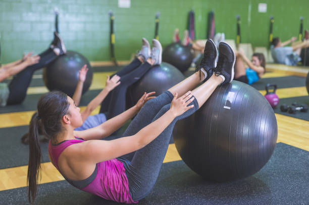 istock Co-ed Group Exercising Together at Fitness Facility 932008454