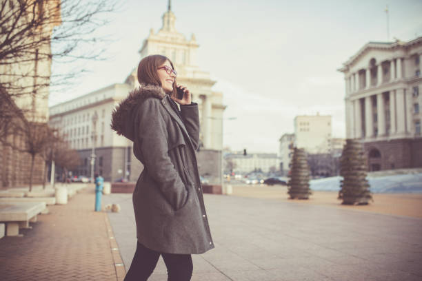 Cute young girl talking on the phone on the street