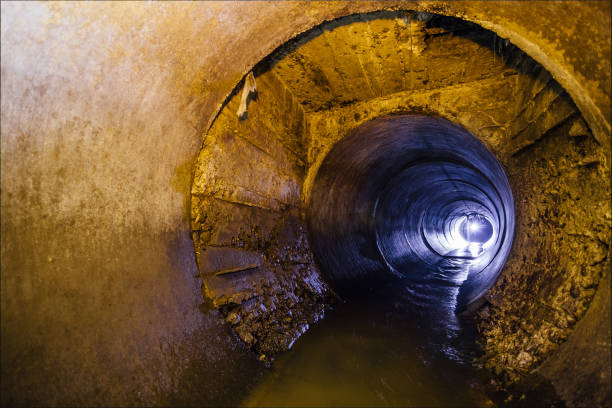 istock Dirty urban sewage flowing throw round sewer tunnel pipe 932016276