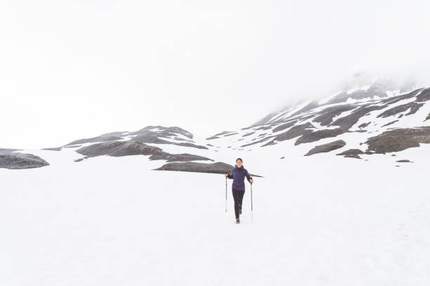 istock Solo ethnic female hiking up a snowy glacier 932026810